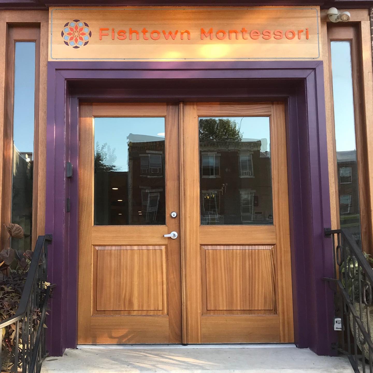 The front doors of Fishtown Montessori on Girard Avenue, framed in purple under the school sign